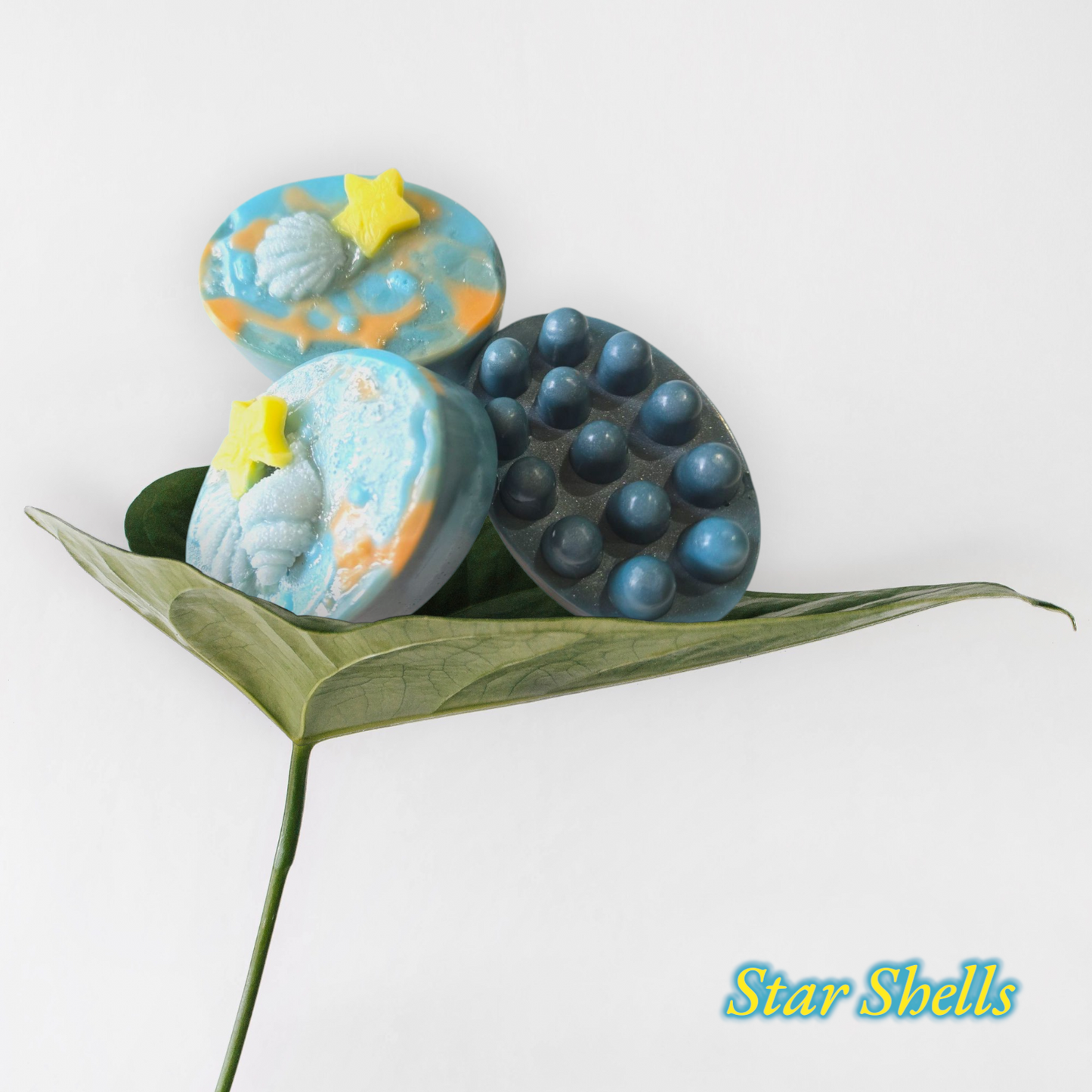 Star Shells Bar Soap with Cocoa, Shea, and Mango Butter on leaf display.