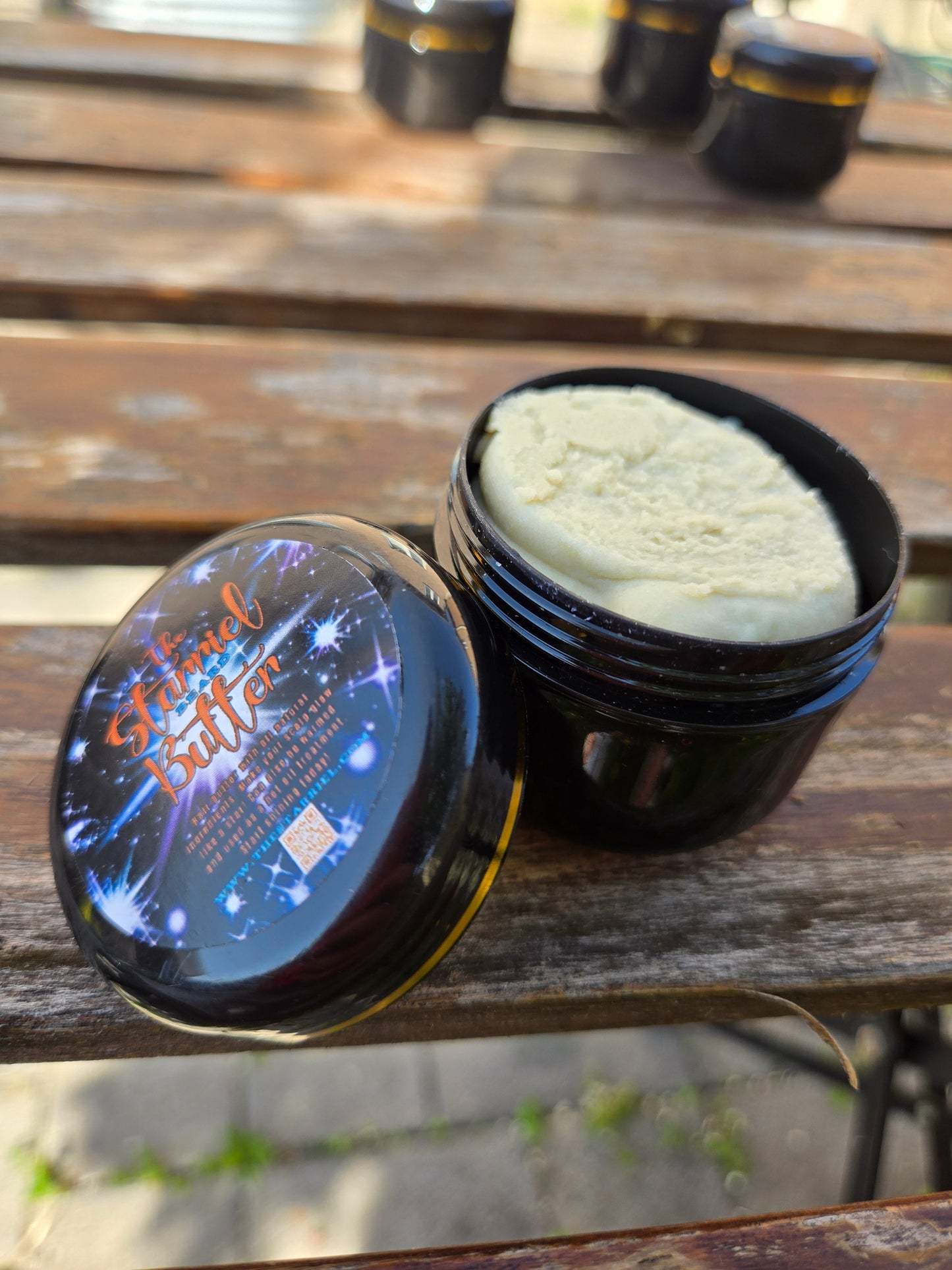 Starriel Beard Butter in an open jar on a wooden table.