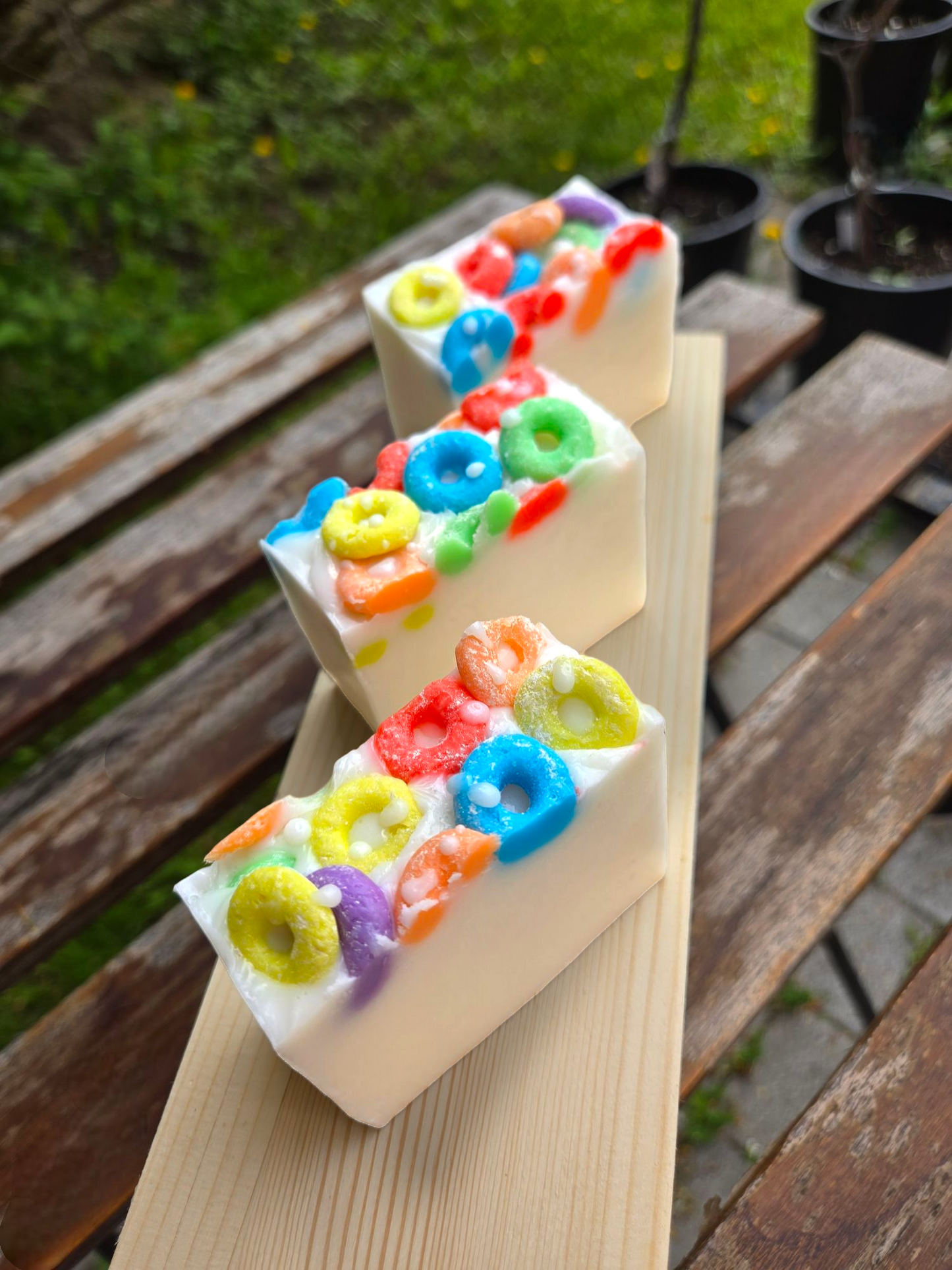 Frooty Loops Bar Soap with colorful cereal-like toppings on a wooden plank.