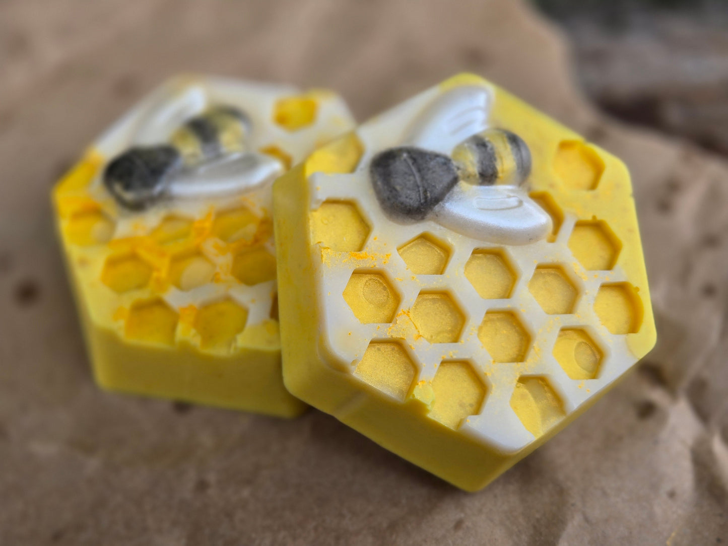 Hexagon-shaped Honey Bar soap with honeycomb and bee design, ideal for cleansing and exfoliating skin.