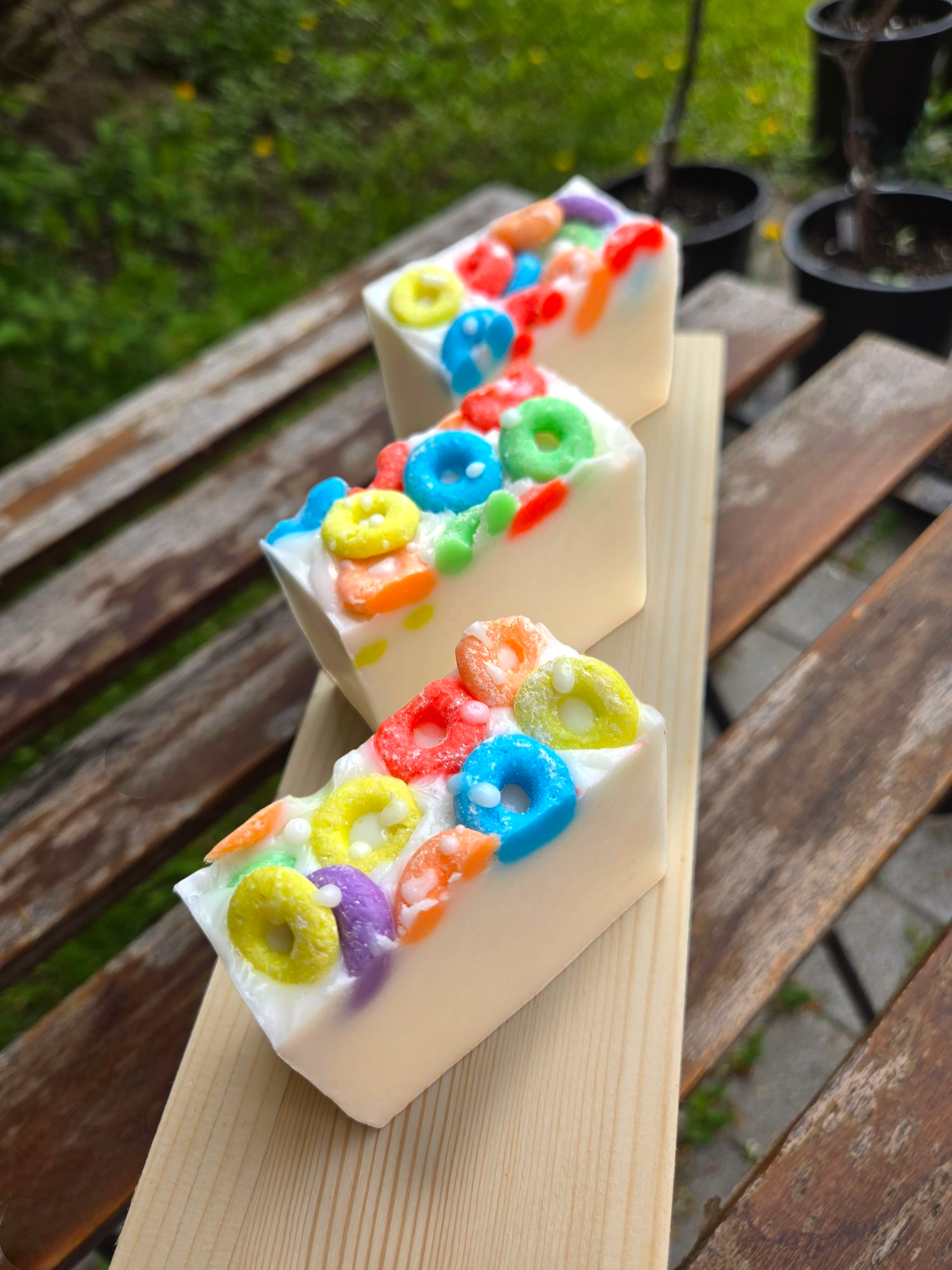 Frooty Loops Bar Soap with colorful cereal-like toppings on a wooden plank.