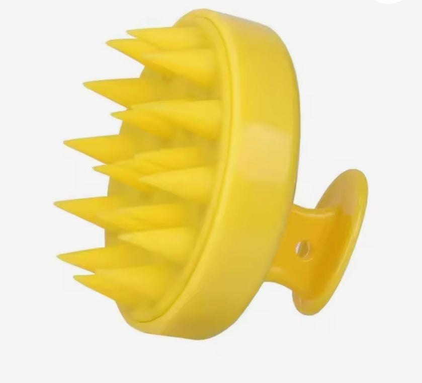 Yellow massage hair brush for hair growth stimulation.